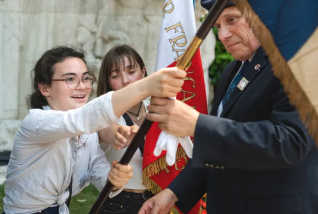 Jeunes porte-drapeaux avec leur parrain en train de s'exercer au maniement du drapeau