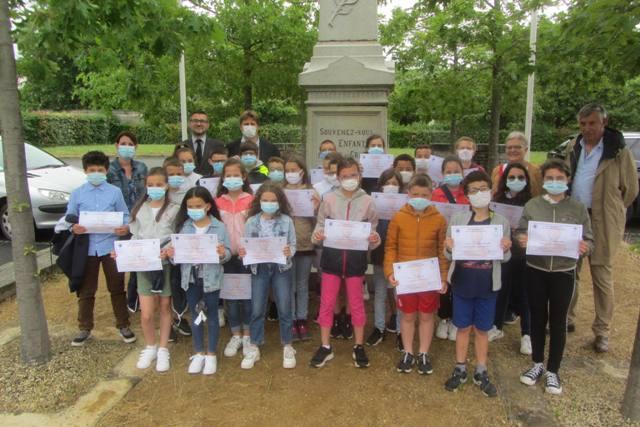 Les enfants de CM1-CM2 et les enseignants de l'école St-Louis, les élus de Bécon-les-Granits et le directeur du SD49 devant le monument aux Morts de la commune