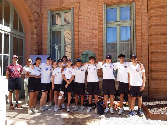 Un groupe de jeunes volontaires posant devant la stèle Jean Moulin