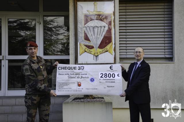 Le chef de corps du 3ème RPIMa remet un imposant chèque au directeur du service de l