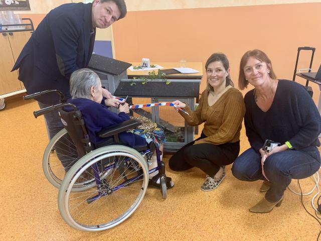 Une résidente qui tranche le ruban présent sur la cage des cochons d’Inde