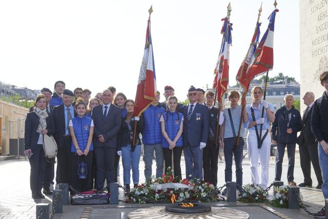 Groupe de jeunes et leurs accompagnateurs devant la Flamme de l'Arc de Triomphe